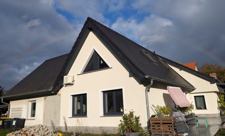 Bauelemente wie Innentüren und dunkle Fensterrahmen passen zur beigen Fassade.